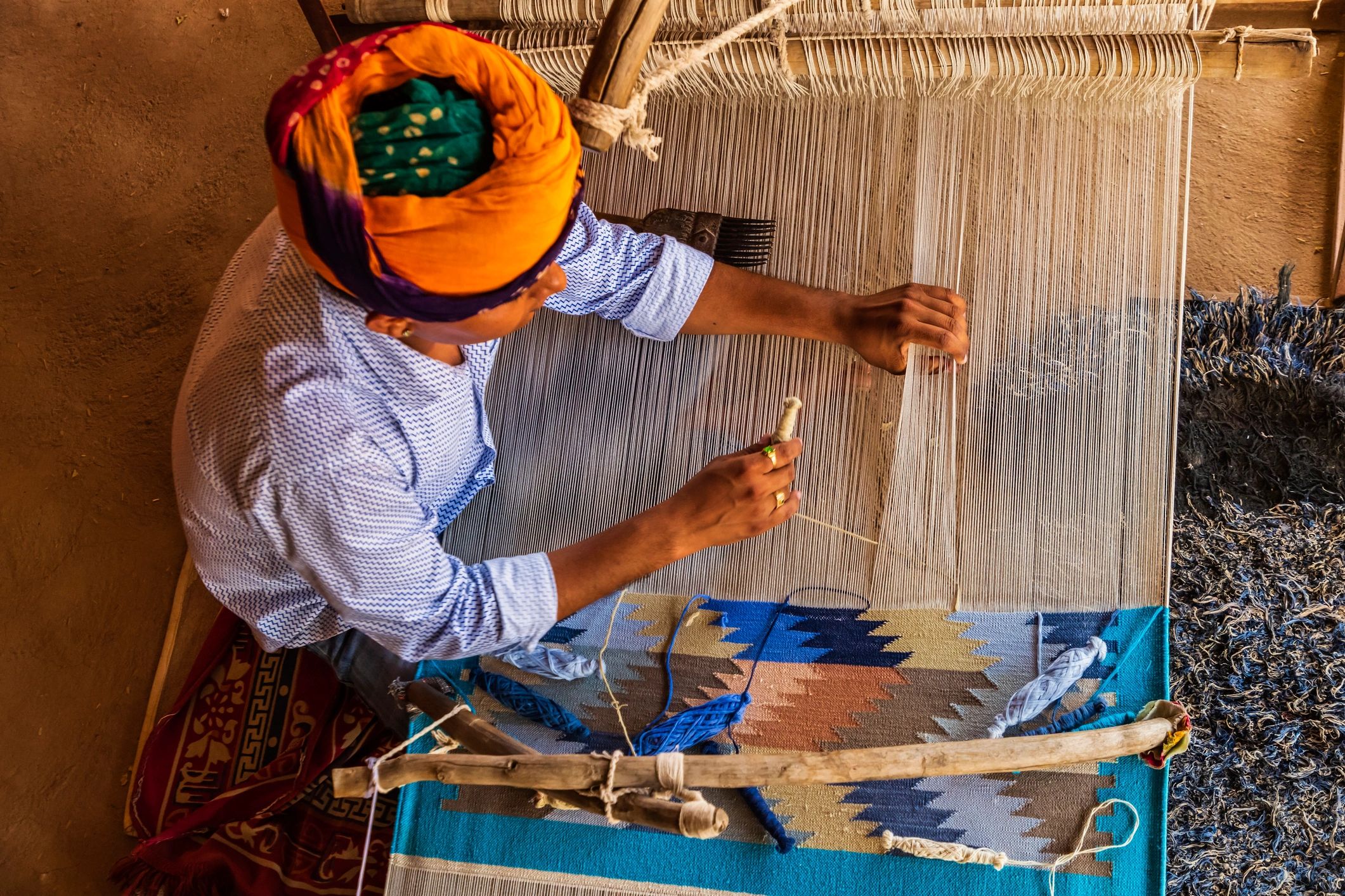 Artisan weaving a traditional Indian rug