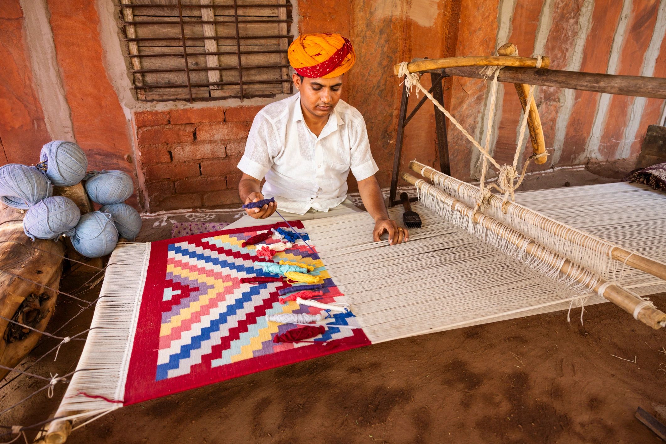 Traditional rug weaver working at a loom in India