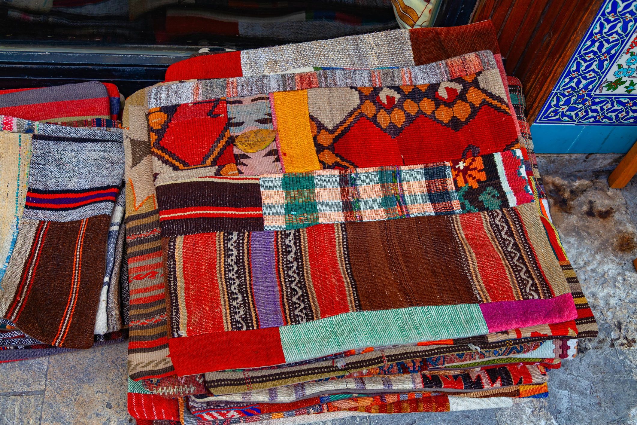 Stacked handwoven kilim rugs with colorful textile patterns